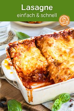 lasagna in a casserole dish on a wooden table with basil leaves