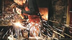 a man working on some kind of metal object with sparks coming out of his hands