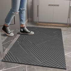 a person standing on a rug in a kitchen