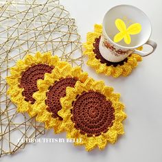 two crocheted sunflower coasters next to a coffee cup