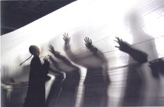 several people reaching out their hands to touch the wall