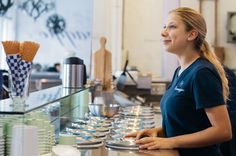 a woman standing in front of a counter filled with plates