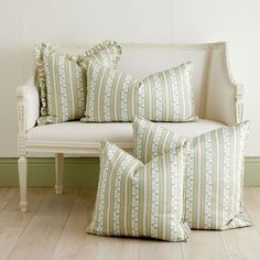 three pillows sitting on top of a white couch