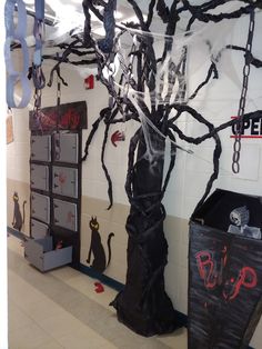 a room decorated for halloween with black and white decorations on the walls, plastic wrapped around a tree