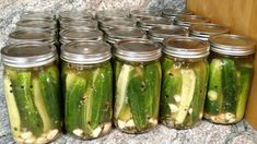 several jars filled with pickles sitting on top of a counter