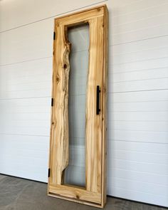 a large wooden object sitting on top of a floor next to a white garage wall