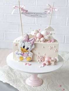 a white cake with pink frosting and an image of a ducky on top