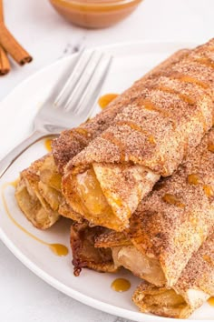 some food is on a white plate with a fork next to it and cinnamon sprinkles