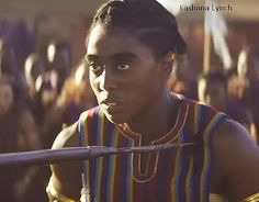 a young man holding a baseball bat in front of a group of people wearing native american clothing