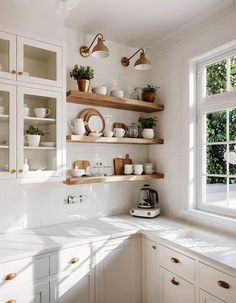 a kitchen with white cabinets and open shelves