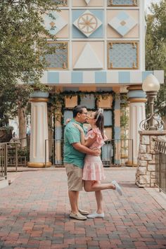 a man and woman kissing in front of a building