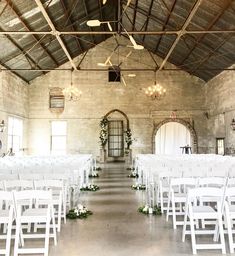 an indoor wedding venue with white folding chairs