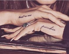 two people with tattoos on their fingers and one has a green stone in her hand