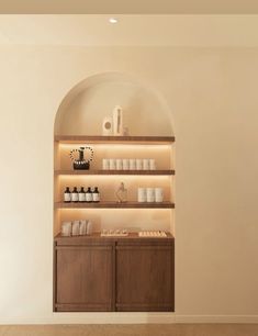 an empty room with shelves filled with bottles and cups on top of each shelf in front of the wall