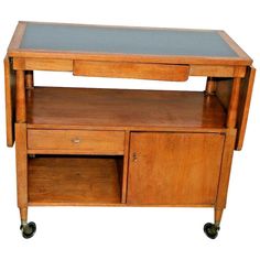 a wooden table with two drawers on wheels