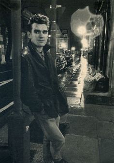 black and white photograph of man standing on sidewalk