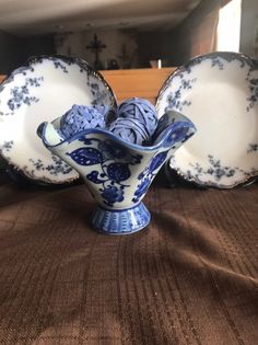 three blue and white dishes sitting on top of a brown tablecloth covered bed in a room