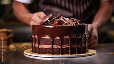 a chocolate cake is being cut by a person with a knife and fork in front of it