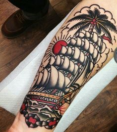 a man's arm with a ship and palm tree on it