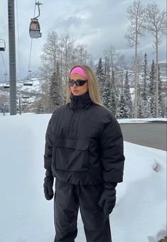 a woman standing in the snow wearing skis