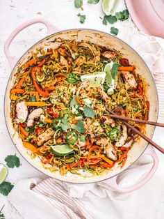 a skillet filled with chicken and veggies on top of a white table