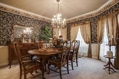 a dining room with floral wallpaper and chandelier