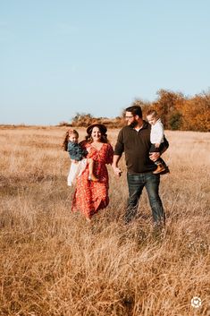 a family walking through tall grass holding hands