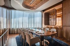 a long table with white chairs in front of a large mirror and wooden paneled walls