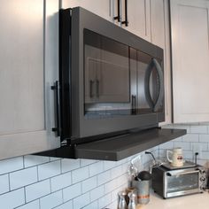 a microwave oven mounted on the wall above a counter