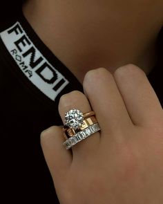 a close up of a person's hand with a diamond ring on their finger