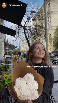 a woman sitting on a bench holding a bouquet of flowers with the caption, the best way to make me smile