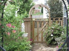 an open gate in the middle of a garden