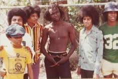 a group of young men standing next to each other in front of a chain link fence