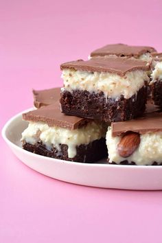 several pieces of cake sitting on top of a white plate with chocolate frosting and almonds