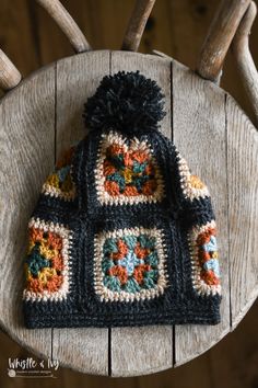 a crocheted hat sitting on top of a wooden chair