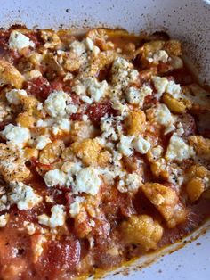 a close up of a plate of food with sauce and cheese on top, in a bowl