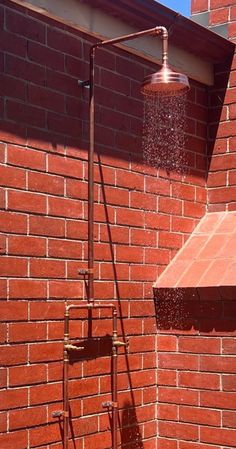 a red brick building with a shower head and faucet