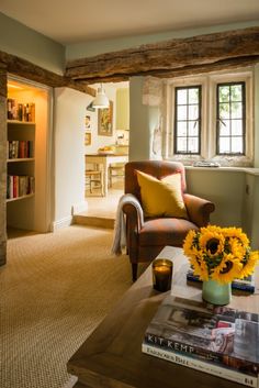 a living room filled with furniture and a fire place in front of a book shelf