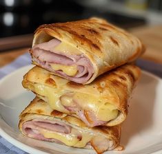 two ham and cheese quesadillas stacked on top of each other in a white plate