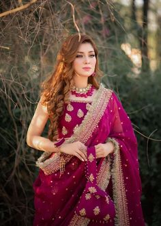 a beautiful woman in a purple outfit posing for the camera with her hands on her hips