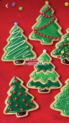 decorated cookies in the shape of christmas trees on a red background with confetti stars