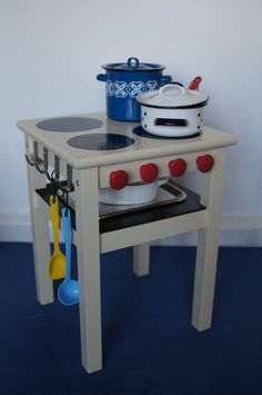 a toy stove with pots and pans on it