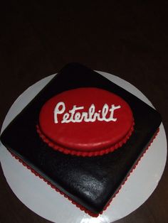 a red and black cake with the word peterit on it sitting on a white plate