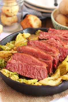 corned beef and cabbage in a cast iron skillet with potatoes on the side