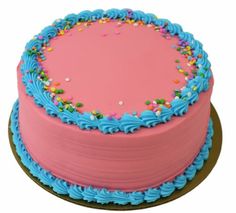 a pink cake with blue frosting and sprinkles on the top is shown