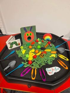 a child's play tray with scissors, cards and magnets on it in the shape of a caterpillar