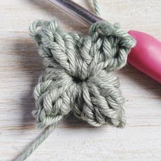 the crochet hook is being used to make an ornament with yarn