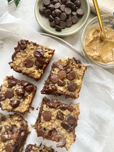 chocolate chip cookie bars on parchment paper next to bowls of peanut butter