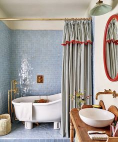 a bath room with a tub a sink and a mirror on the wall next to a table