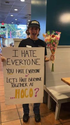 a man holding a sign that says i hate everyone you hate everyone let's hate everyone together at hoco